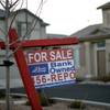 In this Feb. 8, 2008, file photo, a for-sale sign stands in front of a bank-owned home in Las Vegas.
